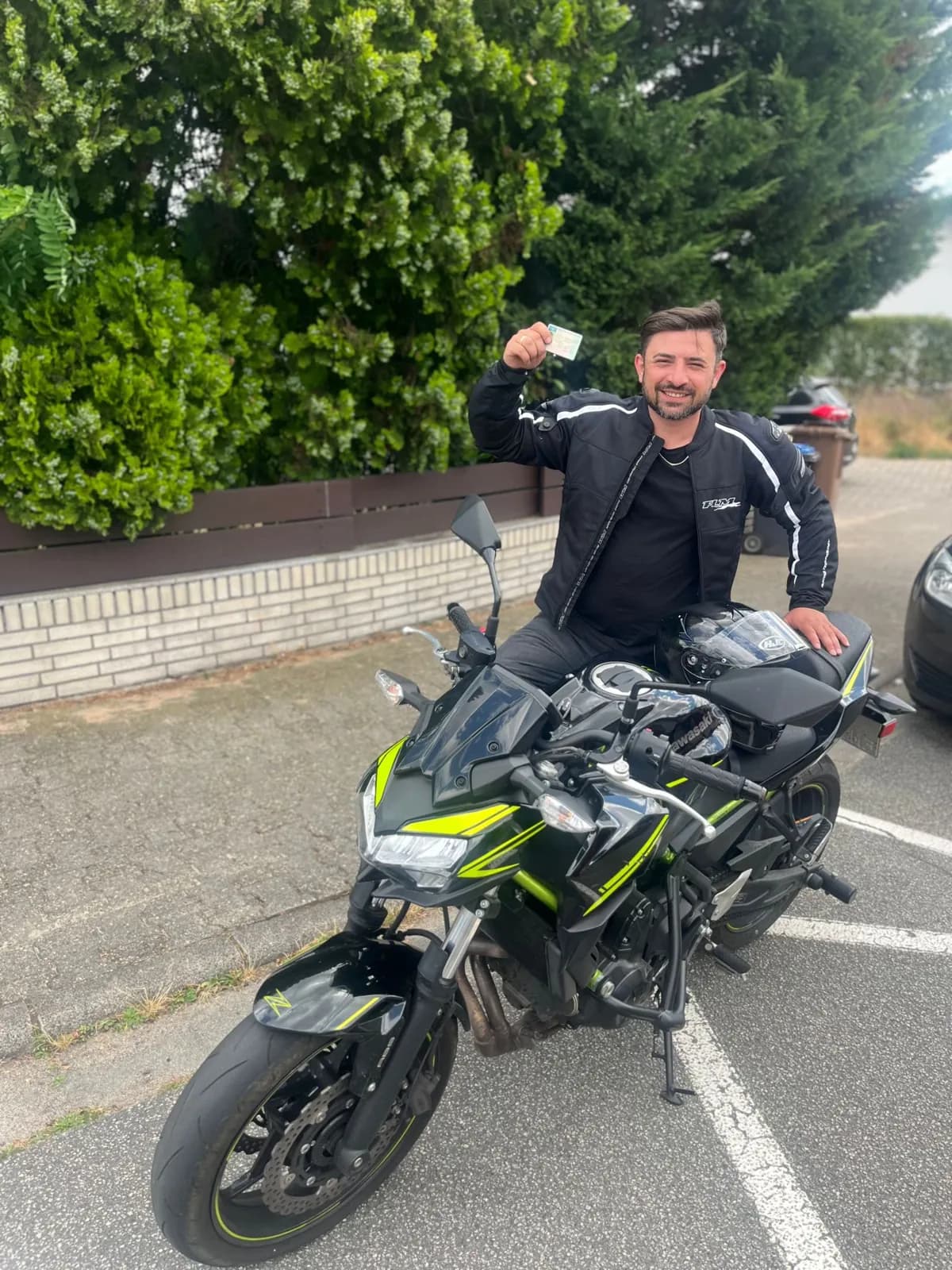 Fahrschüler zeigt stolz seinen neuen Motorradführerschein